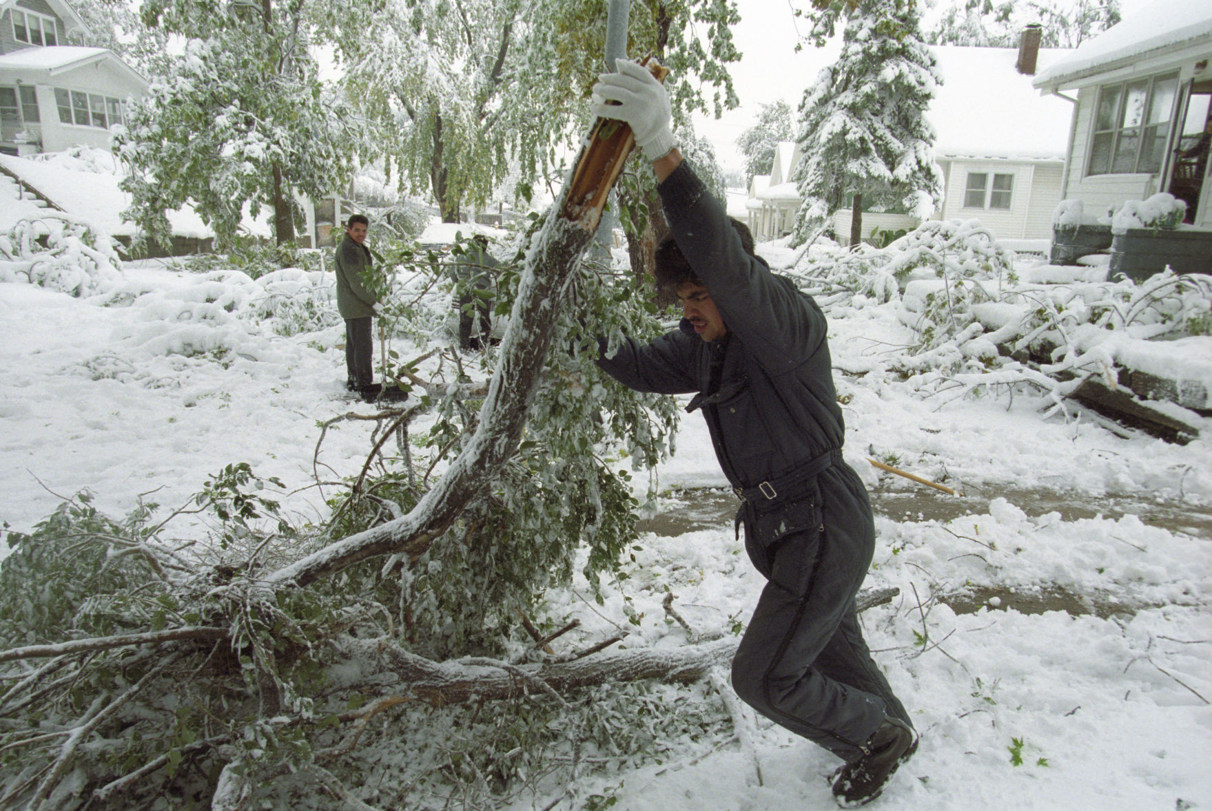 Jose Moreno moves a fallen branch off his property near 15th and Center Streets.